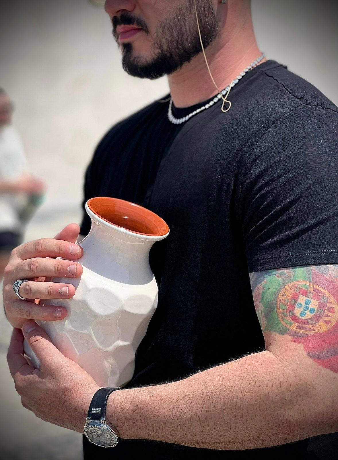 Artisan holding a handcrafted Portuguese ceramic vase